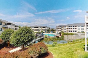 A residential building with a swimming pool, a bridge, and a small pond. - The Palms condo near the beach with on-site pool & enclosed patio (Rehoboth Beach)