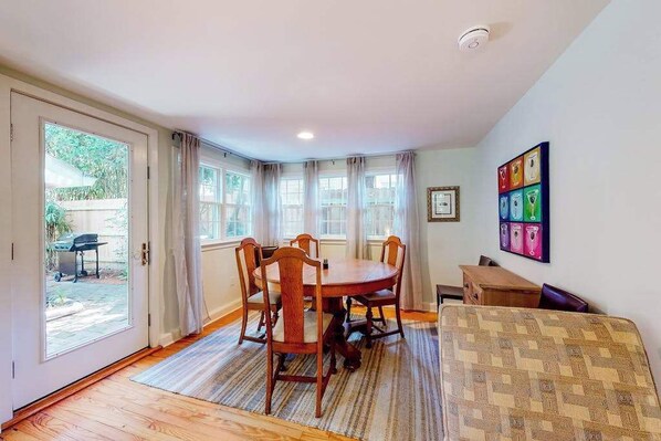 A dining area with a round table, chairs, and a rug. - Town of Rehoboth Beach home near beach, tennis courts, grill, patio, W/D, WiFi (Rehoboth Beach)