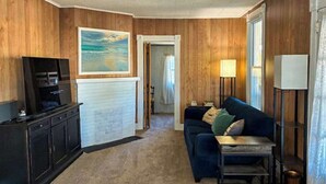 A room with wooden paneling, a television, a couch, a lamp, and a painting. - Town of Rehoboth Beach dog-friendly house close to beach & restaurants (Rehoboth Beach)