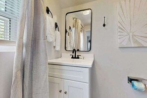 A bathroom with a white sink, a mirror, and a towel rack. - Dog-friendly Rehoboth Beach gem steps from beach & boardwalk with fast WiFi (Rehoboth Beach)