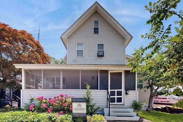 A two-story house with a front porch, a small attached garage, and a signboard. - Dog-friendly Rehoboth Beach gem steps from beach & boardwalk with fast WiFi (Rehoboth Beach)