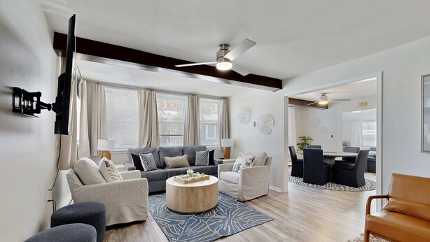 A modern living room with a sofa, armchairs, a coffee table, and a dining area with a table and chairs. - Dog-friendly Rehoboth Beach gem steps from beach & boardwalk with fast WiFi (Rehoboth Beach)