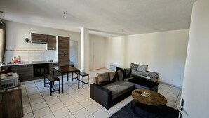 A modern apartment with a kitchen, dining area, and living room. - L'écrin de l'abreuvoir – Cozy Ground-Floor Retreat in Marnay Near Besançon (Marnay)