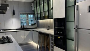 A modern kitchen with a central island, built-in appliances, and a window. - Two Bedroom Luxury Apartment in Wuse 2 (Abuja)