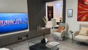 A modern living room with a flat-screen TV, a glass coffee table, and contemporary furniture. - Two Bedroom Luxury Apartment in Wuse 2 (Abuja)