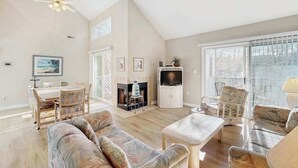 Una sala de estar amplia con chimenea, televisor y comedor.