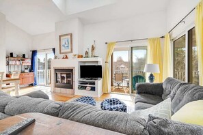 Una sala de estar con chimenea, televisor y sofá.