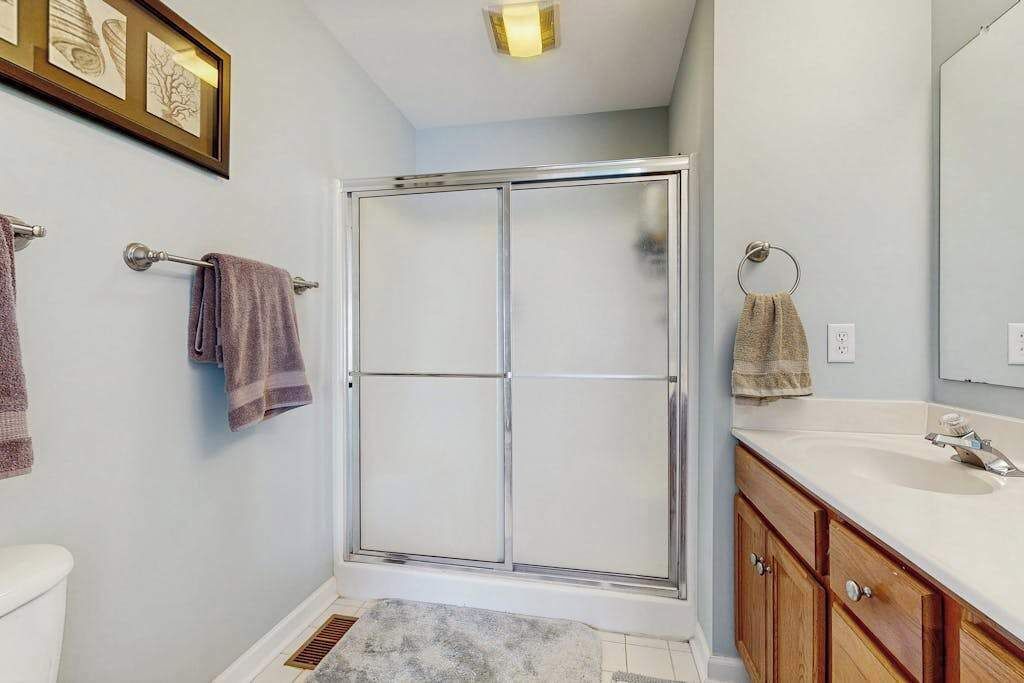 Une salle de bain avec douche, toilettes et lavabo.