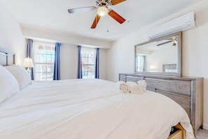 A hotel room with a bed, a ceiling fan, a dresser, a mirror, and a window. - Rehoboth Beach House with seasonal pool, clubhouse, & washer/dryer (Rehoboth Beach)