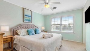 A bedroom with a bed, a ceiling fan, a window, and a painting on the wall. - Versailles at Eagles Landing townhome with pool & tennis - walk to beach shuttle (Rehoboth Beach)