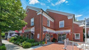 Um edifício de tijolos com uma placa indicando '20 Baltimore Ave. Condominiums'.