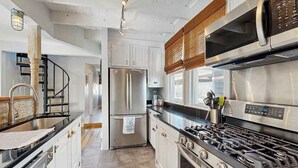 A modern kitchen with stainless steel appliances, a gas stove, and white cabinetry. - Town of Lewes house w/deck, balcony, close to beach & restaurants (Lewes)