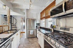 A modern kitchen with stainless steel appliances, a gas stove, and white cabinetry. - Town of Lewes house w/deck, balcony, close to beach & restaurants (Lewes)