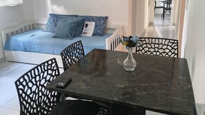 Ein Zimmer mit einem Bett, einem Tisch mit Stühlen und zwei Bildern an der Wand.