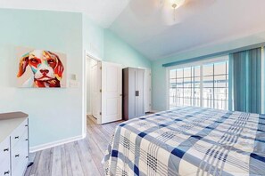 A bedroom with a bed, a wardrobe, a door, and a window. - Rehoboth Crossing townhome with pool, trails, EV charger, gym, balcony (Rehoboth Beach)