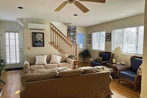 A living room with a sofa, chairs, a staircase, and a ceiling fan. - Town of Rehoboth Beach dog-friendly house close to beach & restaurants (Rehoboth Beach)