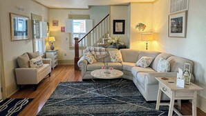 Ein Wohnzimmer mit Sofa, Couchtisch und einer Treppe.