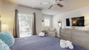 A hotel room with a bed, a ceiling fan, a TV, a dresser, and a chair. - Dog-friendly, 2-story home near beach with private outdoor pool, W/D & AC (Rehoboth Beach)