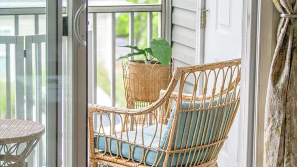 A wicker chair with cushions, a wicker table, and a potted plant on a balcony. - Villas at Bay Crossing dog-friendly condo with pool, balcony, water views, & W/D (Lewes)
