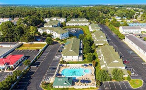 An aerial view of a residential area with multiple houses, a swimming pool, and a parking lot. - The Tides condo with pool access, covered patio, washer/dryer & central AC (Rehoboth Beach)