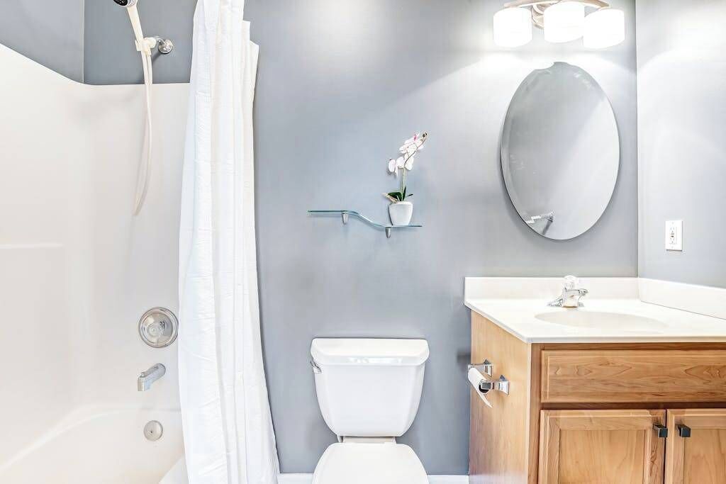 Une salle de bain moderne équipée d’une douche, de toilettes et d’un meuble-lavabo.