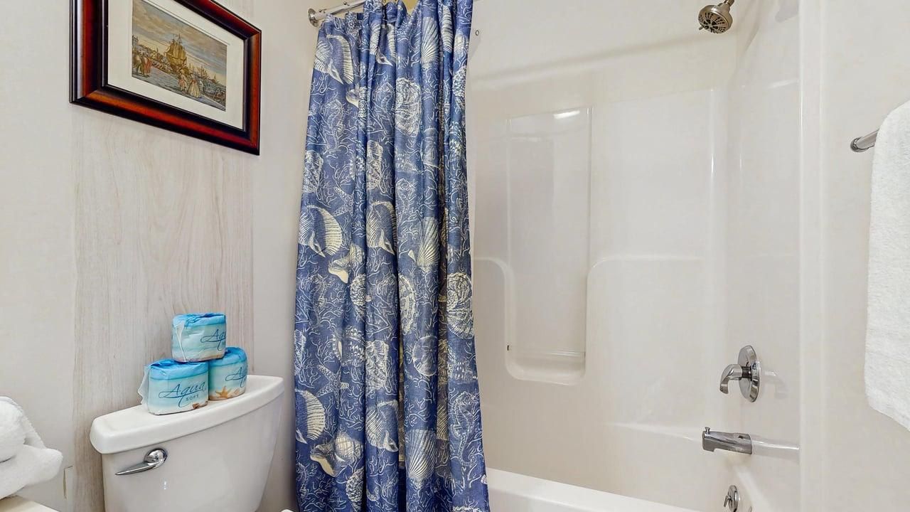A bathroom with a toilet, a shower, and a bathtub.