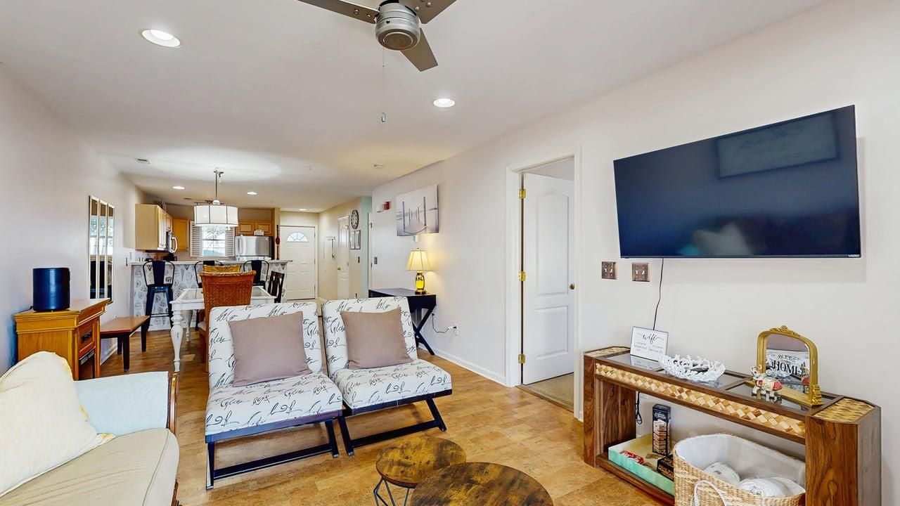 A living room with a sofa, a coffee table, and a television.