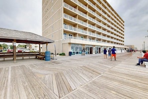 Ein mehrstöckiges Hotel mit Balkonen, einem überdachten Gang und einer Strandlage.