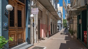 Eine enge Straße mit einem Hotel, einem Hydranten und einem Radfahrer.