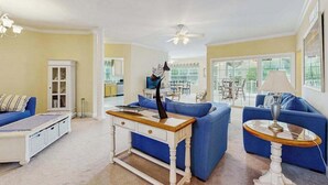 A living room with a sofa, a coffee table, a cabinet, and a ceiling fan. - Keys of Marsh Harbor house w/community pool & tennis court, deck, grill (Rehoboth Beach)