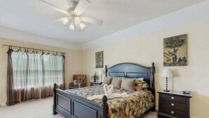 A bedroom with a bed, a nightstand, a ceiling fan, and a window with curtains. - Keys of Marsh Harbor house w/community pool & tennis court, deck, grill (Rehoboth Beach)