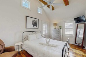 A bedroom with a bed, a ceiling fan, a TV, a dresser, a chair, and a framed picture on the wall. - Town of Lewes Duplex w/deck, close to beach & restaurants (Lewes)