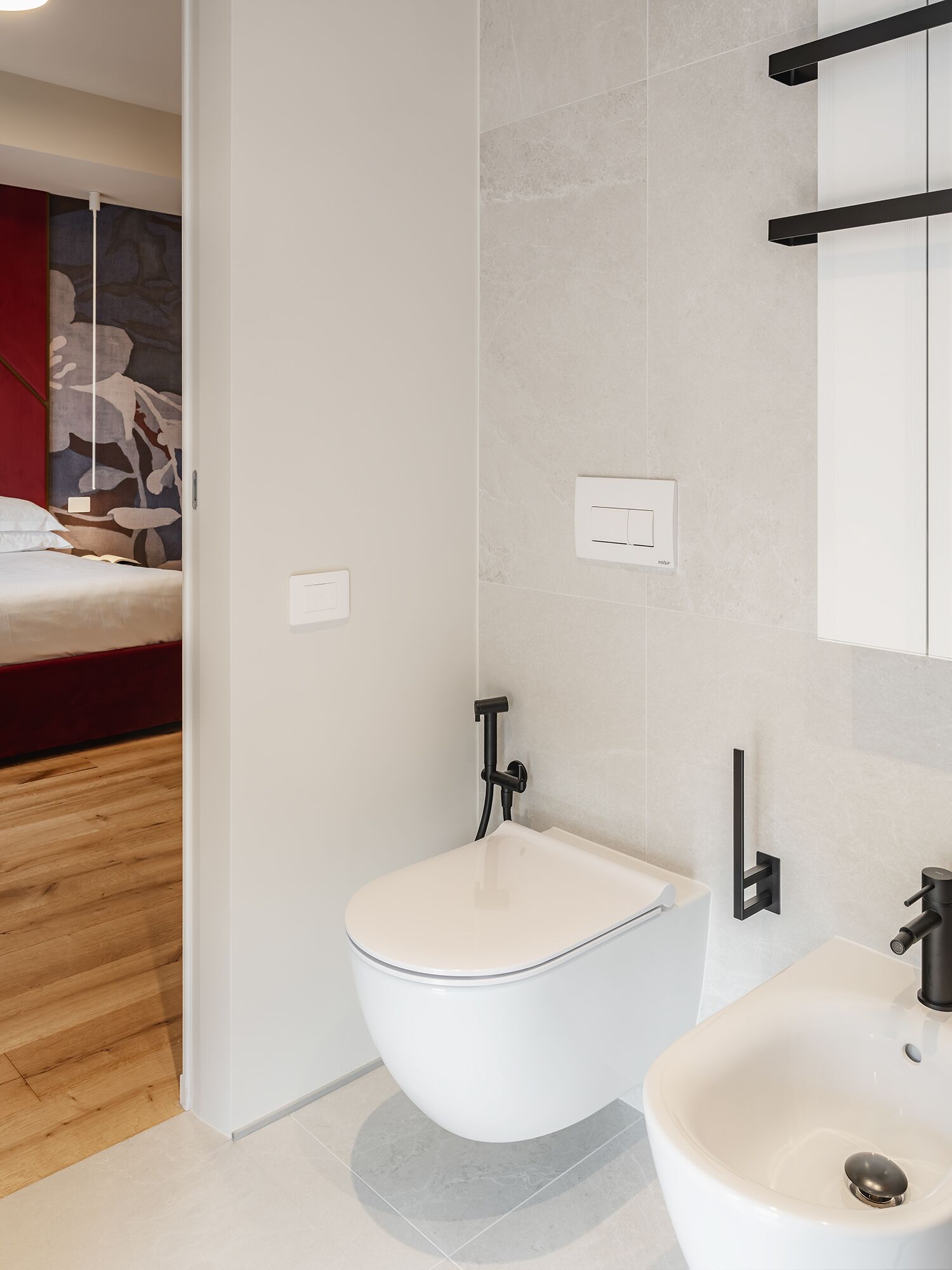 Ein modernes Badezimmer mit Toilette, Bidet und Waschbecken.