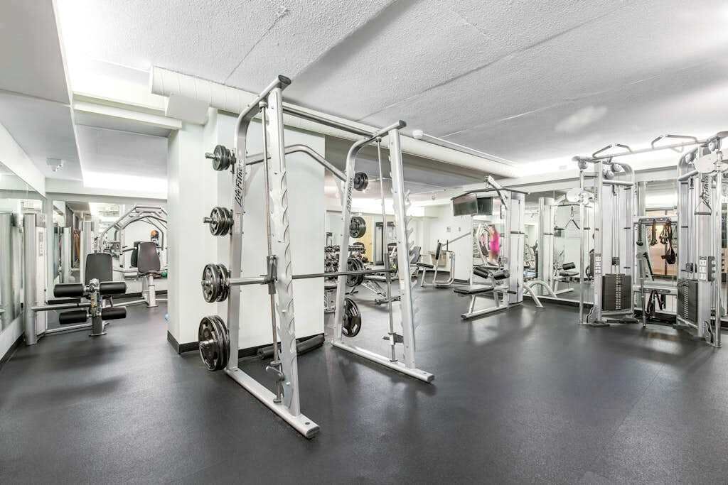 Un gimnasio con diverso equipo de ejercicio, incluyendo máquinas de pesas y pesas libres.