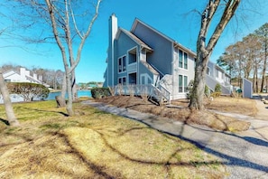 A two-story house with a visible front porch and a small front yard. - Sea Colony Tennis 1st-floor condo with pool, sauna & wifi (Bethany Beach)