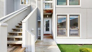 A multi-level wooden staircase leading to a door with a window above. - 1st-floor Sea Colony Tennis condo with pool, gym, & fireplace (Bethany Beach)