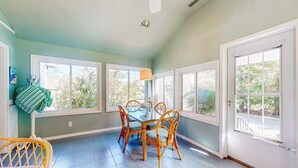 A dining area with a table and chairs, large windows, and a ceiling fan. - Town of Rehoboth Beach home in a great location with yard and 3-season room (Rehoboth Beach)