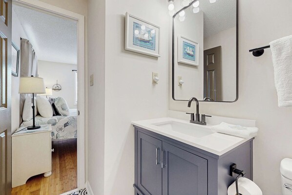 A bathroom with a sink, mirror, and towel rack. - Beachaven pet friendly condo w/community pool, patio, close to restaurants (Rehoboth Beach)