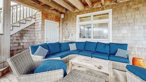 Un espace extérieur abrité, doté d’un plafond en bois, d’une porte blanche et d’un mur en briques.
