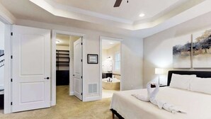 A hotel room with a bed, a bathroom, and a staircase leading to another room. - Upgraded home with pools, sports courts, bikes, chef's kitchen, firepit, & gym (Rehoboth Beach)