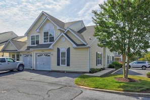 A two-story residential building with a gabled roof, a garage, and a well-maintained lawn. - Home near the ocean with a pool, outdoor space, WiFi, central AC, & washer/dryer (Rehoboth Beach)