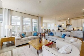 A spacious living area with two sofas, a coffee table, and a dining table. - Oyster House Village house w/community pool, private hot tub, kayaks (Rehoboth Beach)