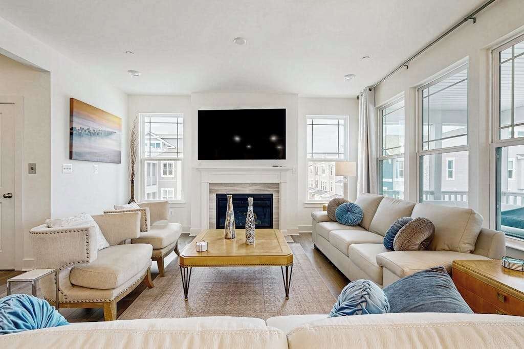 A living room with a fireplace, a flat-screen TV, and a large window.
