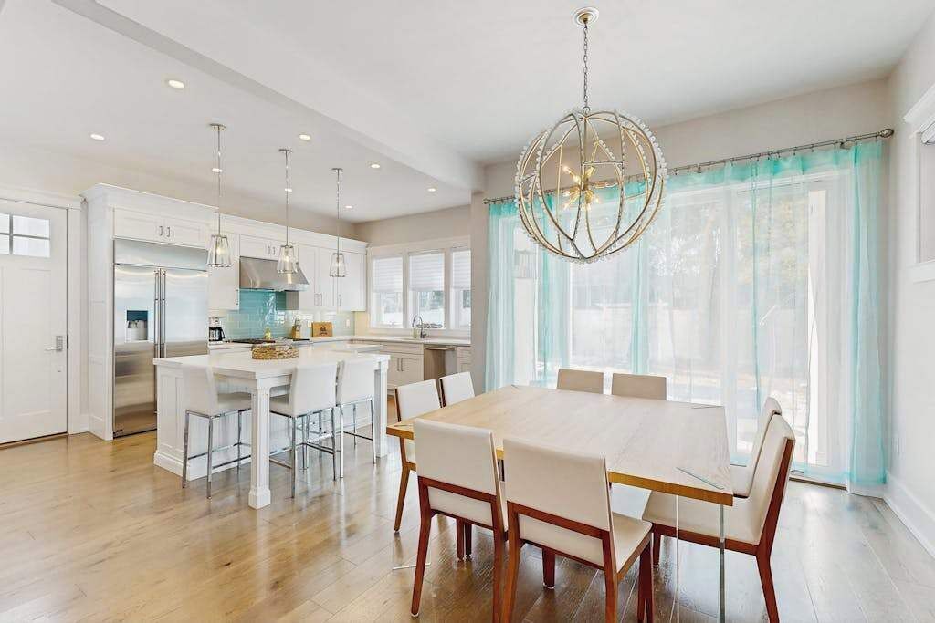 A modern kitchen with white cabinets, a central island, and pendant lighting.