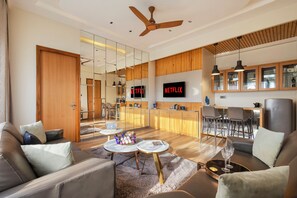 Un salon moderne avec un canapé, une table basse et un téléviseur fixé au mur.