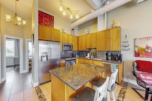 A modern kitchen with granite countertops, stainless steel appliances, wooden cabinets, and a central island. - Rehoboth Beach dog friendly townhome w/deck, patio, grill close to marina (Rehoboth Beach)