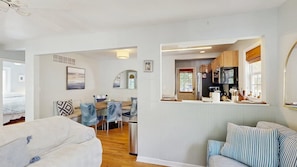 A modern interior with a dining area, kitchen, and seating space. - Town of  Rehoboth Beach condo with screened porch & W/D - walk to beach (Rehoboth Beach)