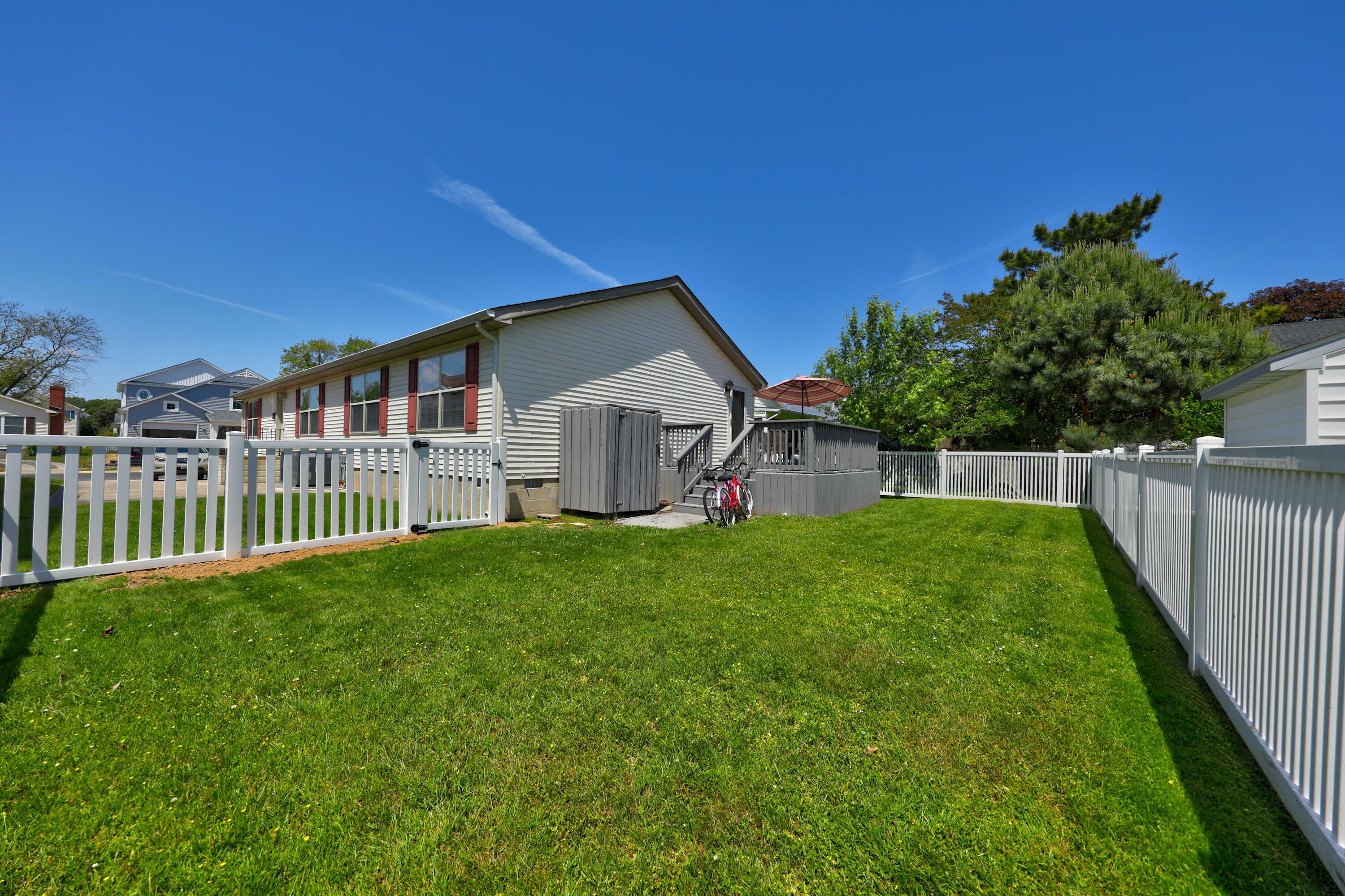 A residential property with a fenced yard, a garage, and a small shed.