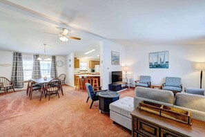 A spacious living area with a dining table, sofas, and a fireplace. - Affordable dog-frienedly beach home w/private deck, gas grill, enclosed yard (Rehoboth Beach)