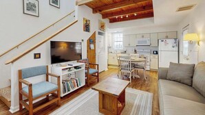 Ein modernes Wohnzimmer mit Fernseher, Bücherregalen und einer Couch.